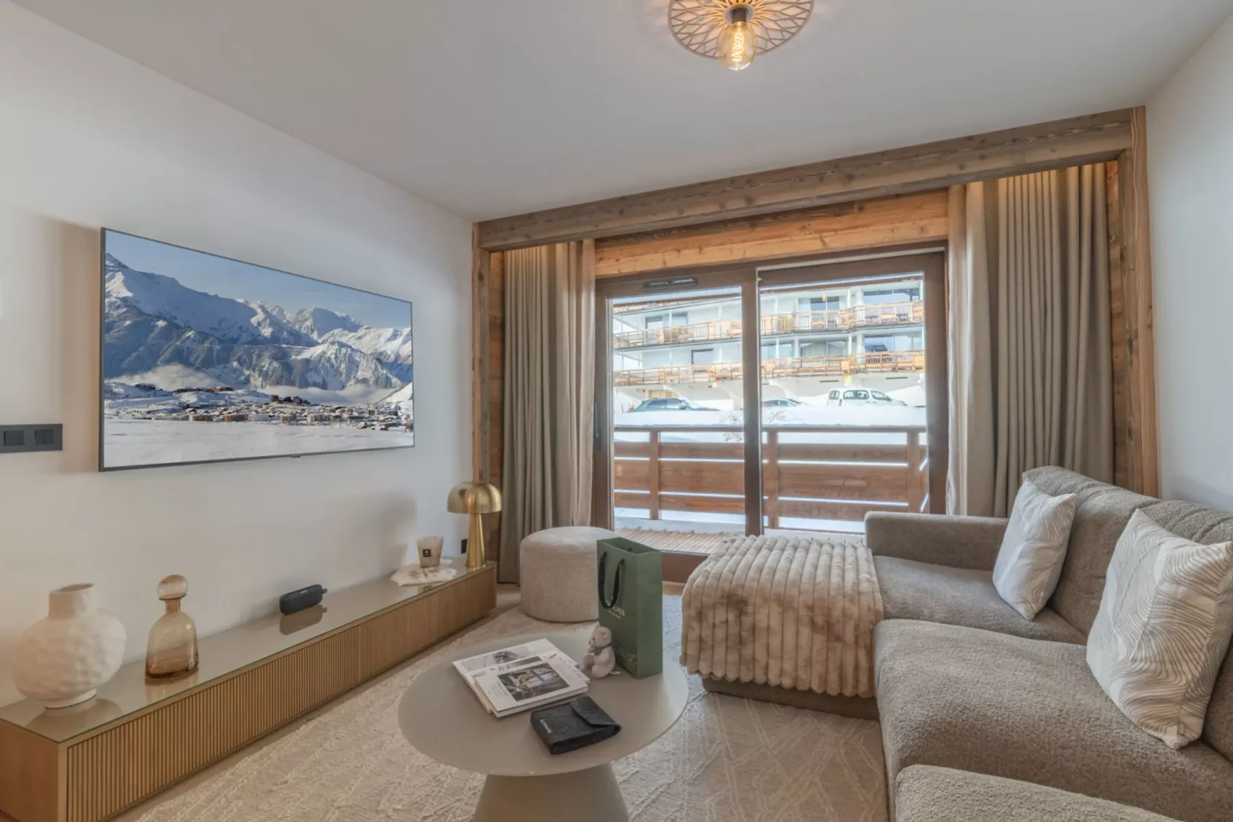 A living room with seating, a low table, and a window overlooking a snowy landscape.