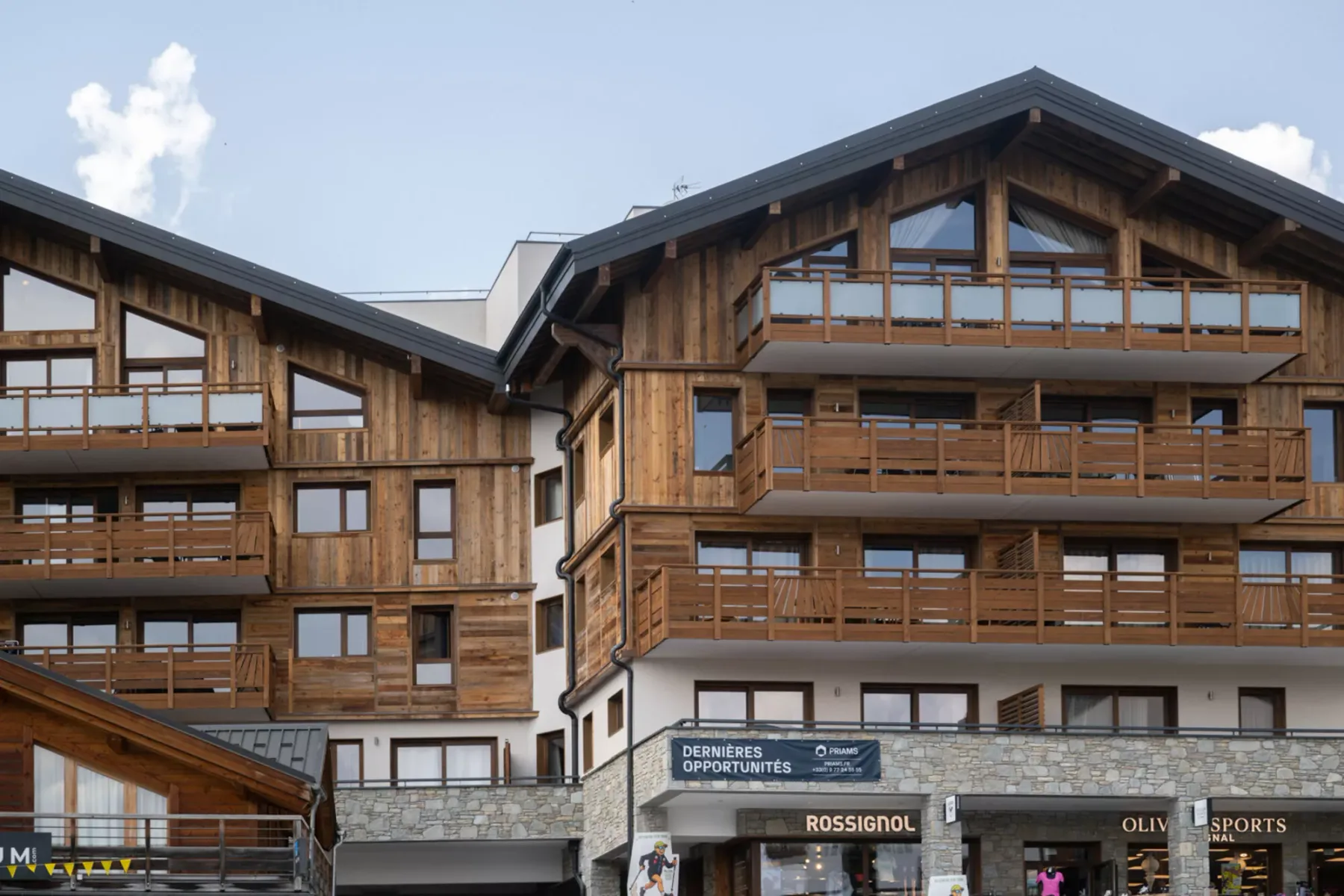 A multi-story building with wooden balconies and shops at street level.