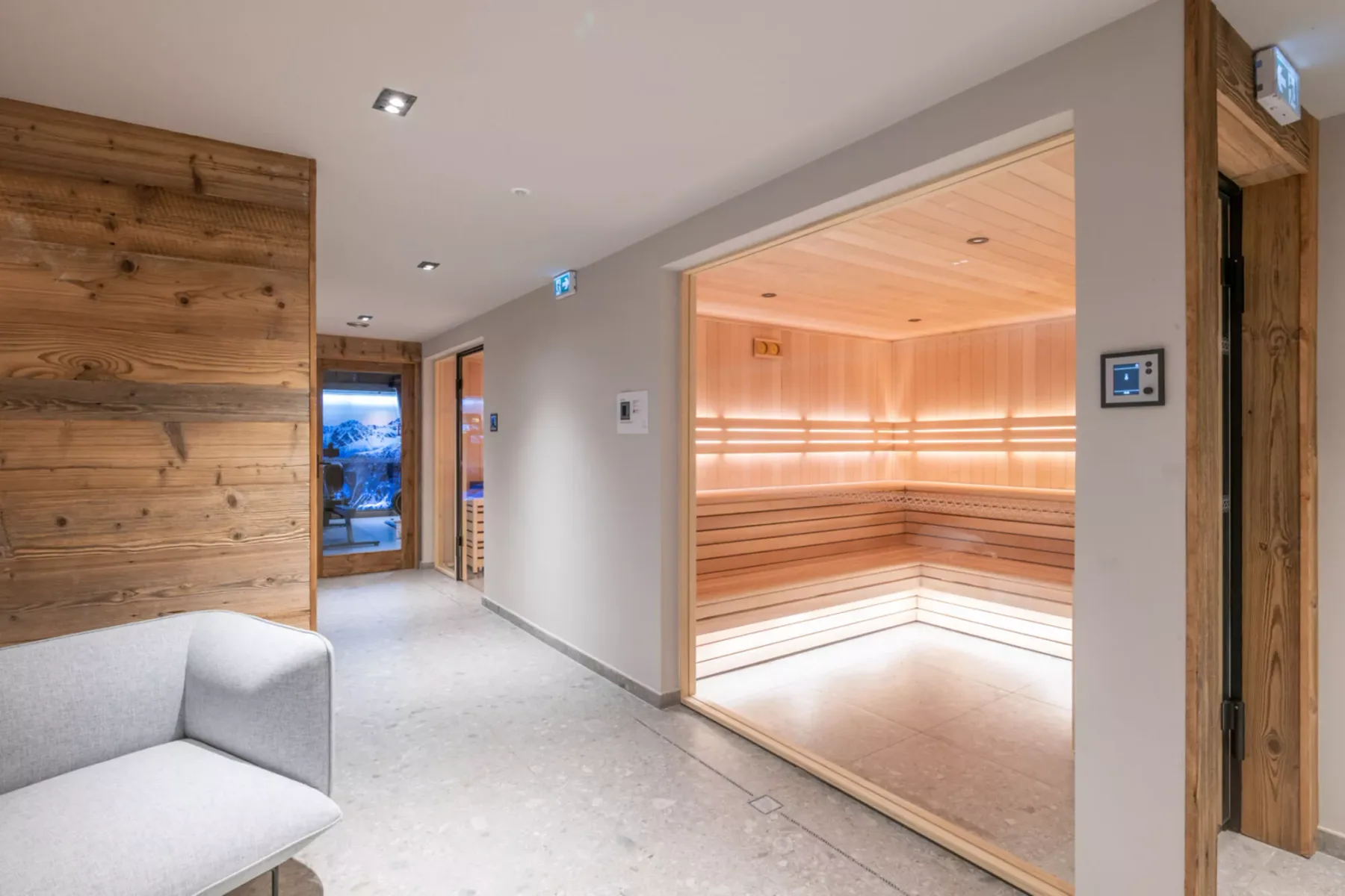 A bright interior hallway opens into a wood-paneled sauna.