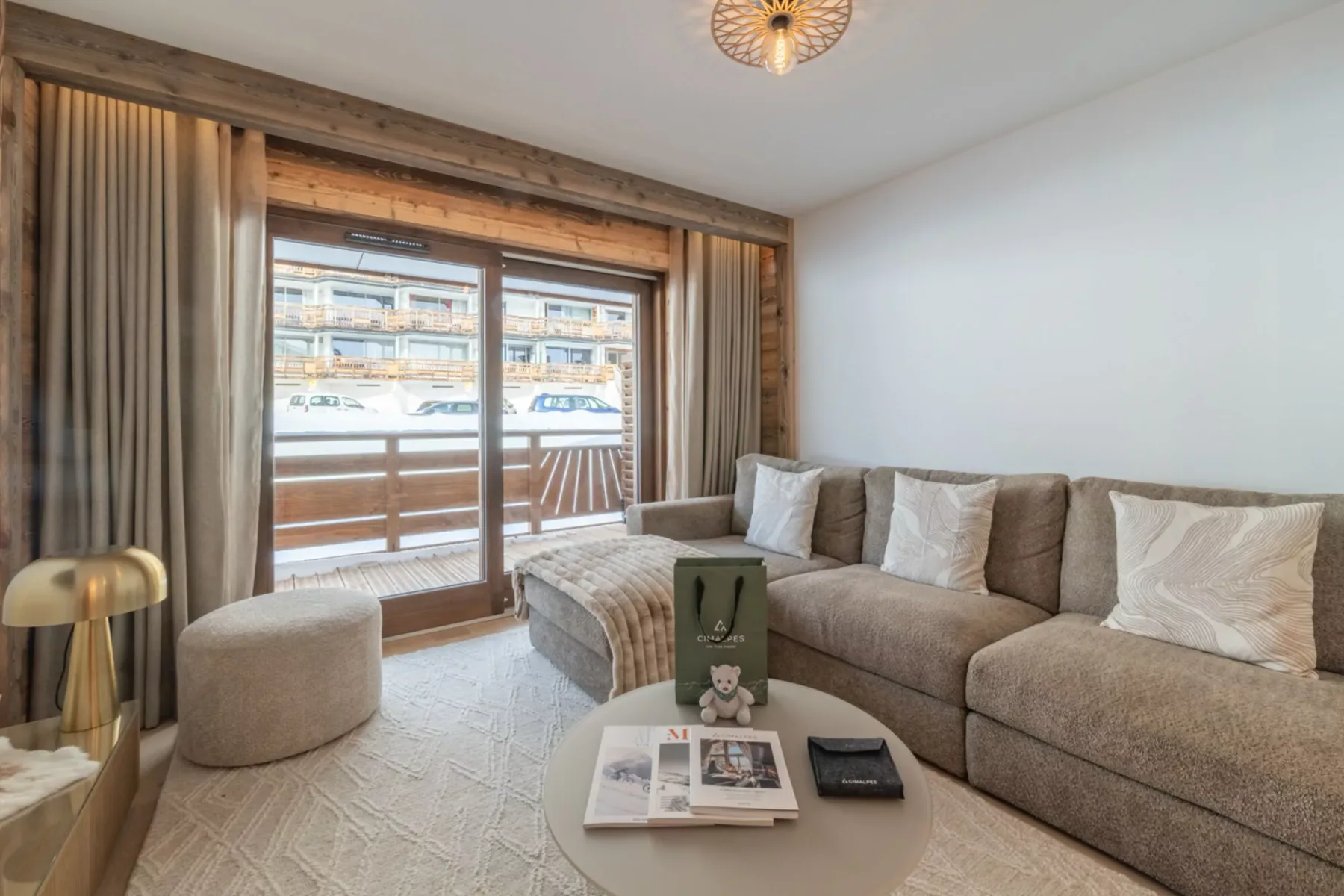 A living room with sectional seating and glass doors opening onto a balcony.