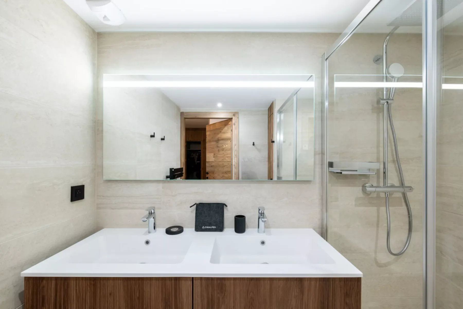 A bathroom with a wide vanity and a glass-enclosed shower.