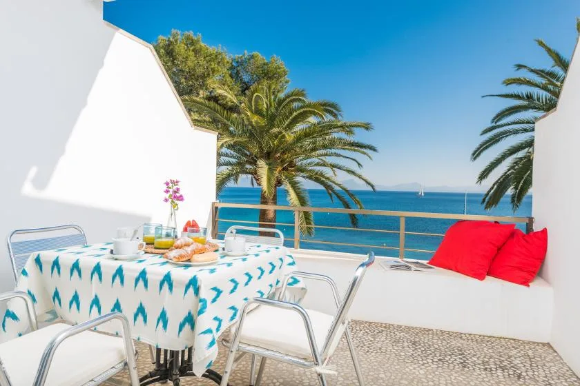 Un comedor al aire libre con vistas al mar, una mesa y asientos integrados.
