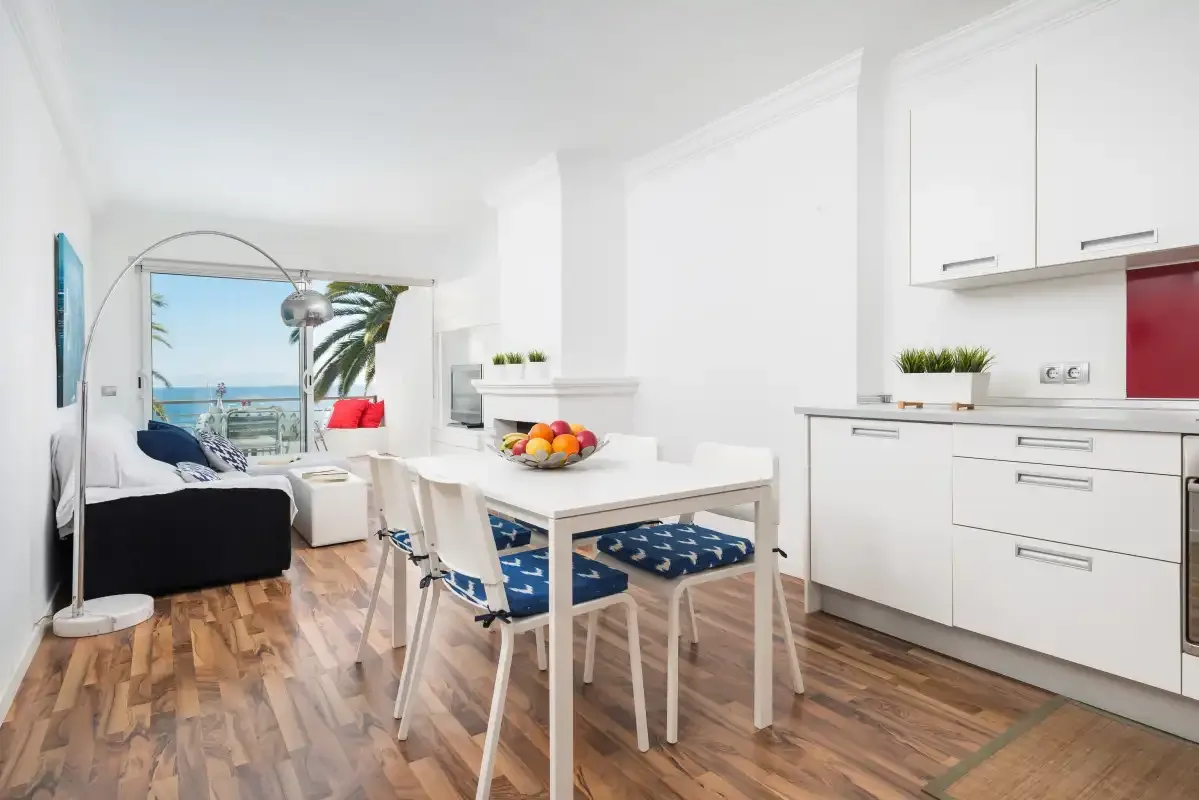Una luminosa sala-comedor de planta abierta con cocina y vistas al mar.