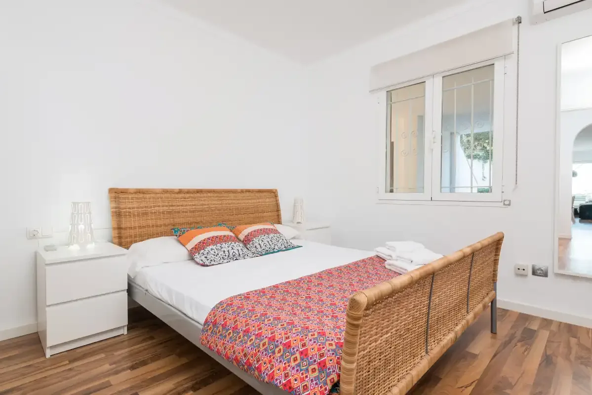 Un dormitorio luminoso con una cama y una ventana.