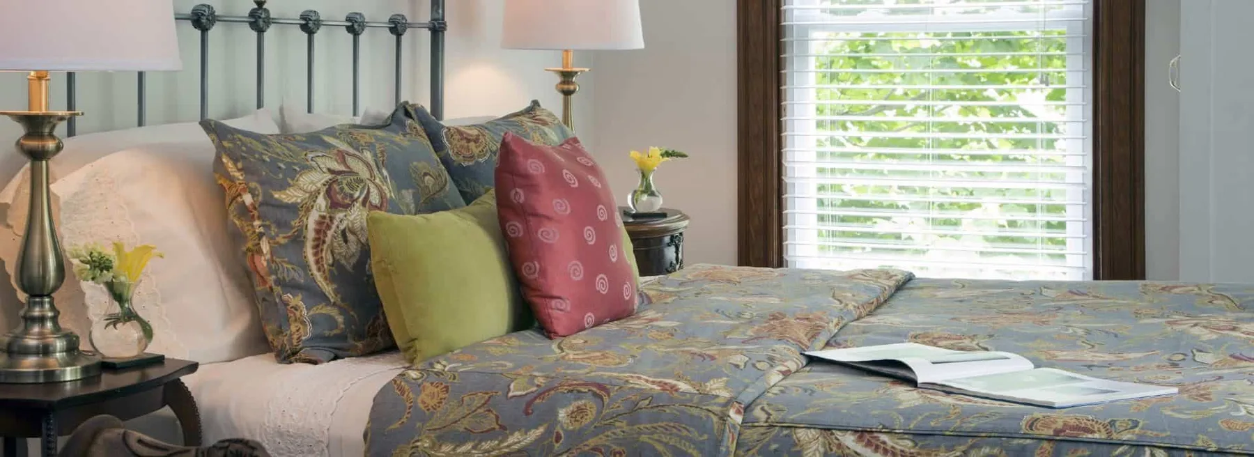 Guest room with wrought-iron headboard and multicolored bedding