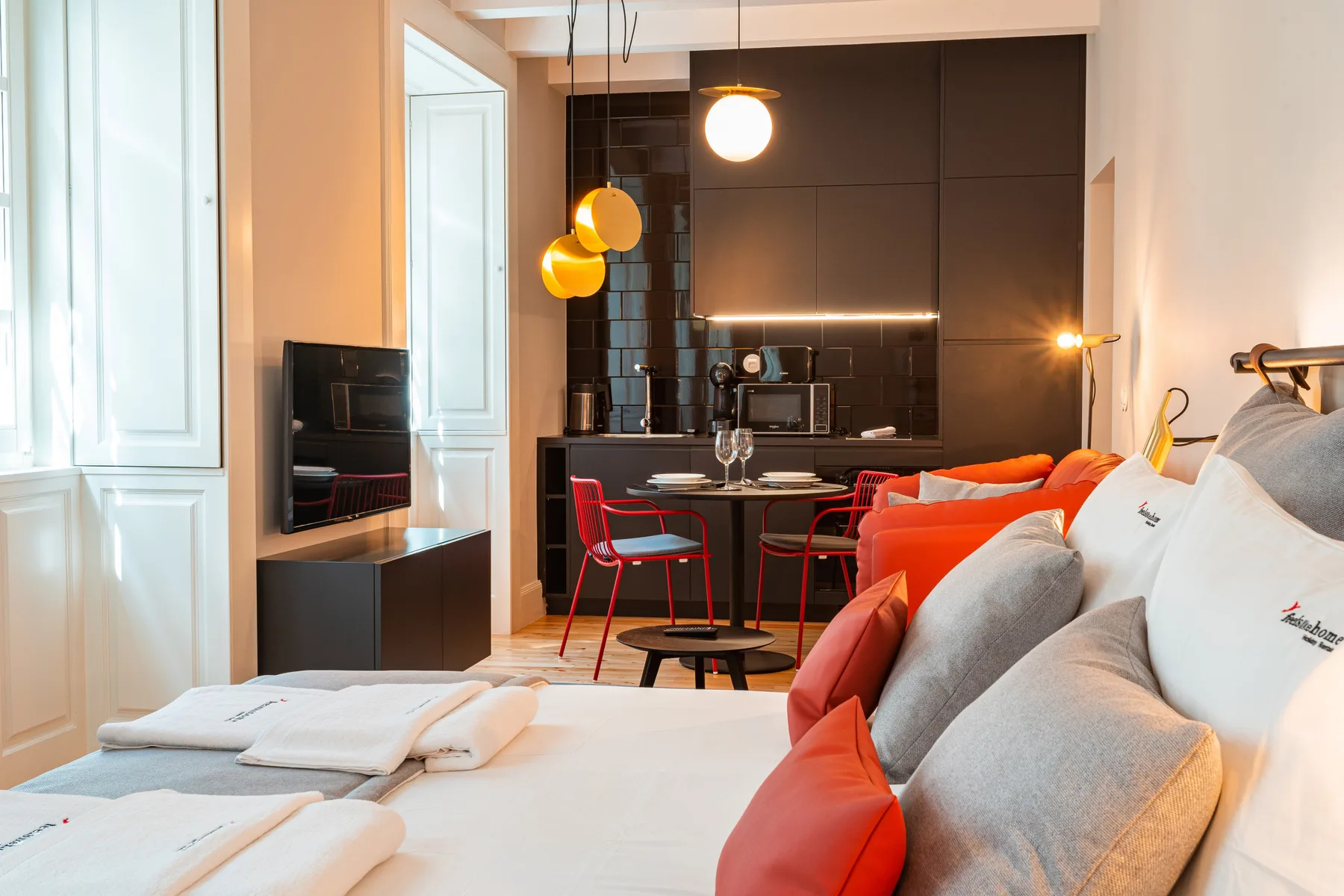 Una zona de estar tipo estudio con cama, asientos y mesa de comedor.