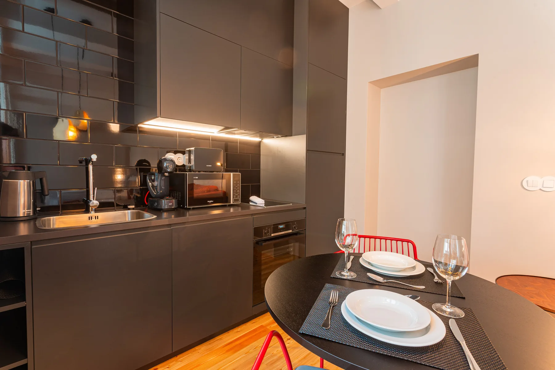Una cocina compacta se abre a una zona de comedor con la mesa puesta.