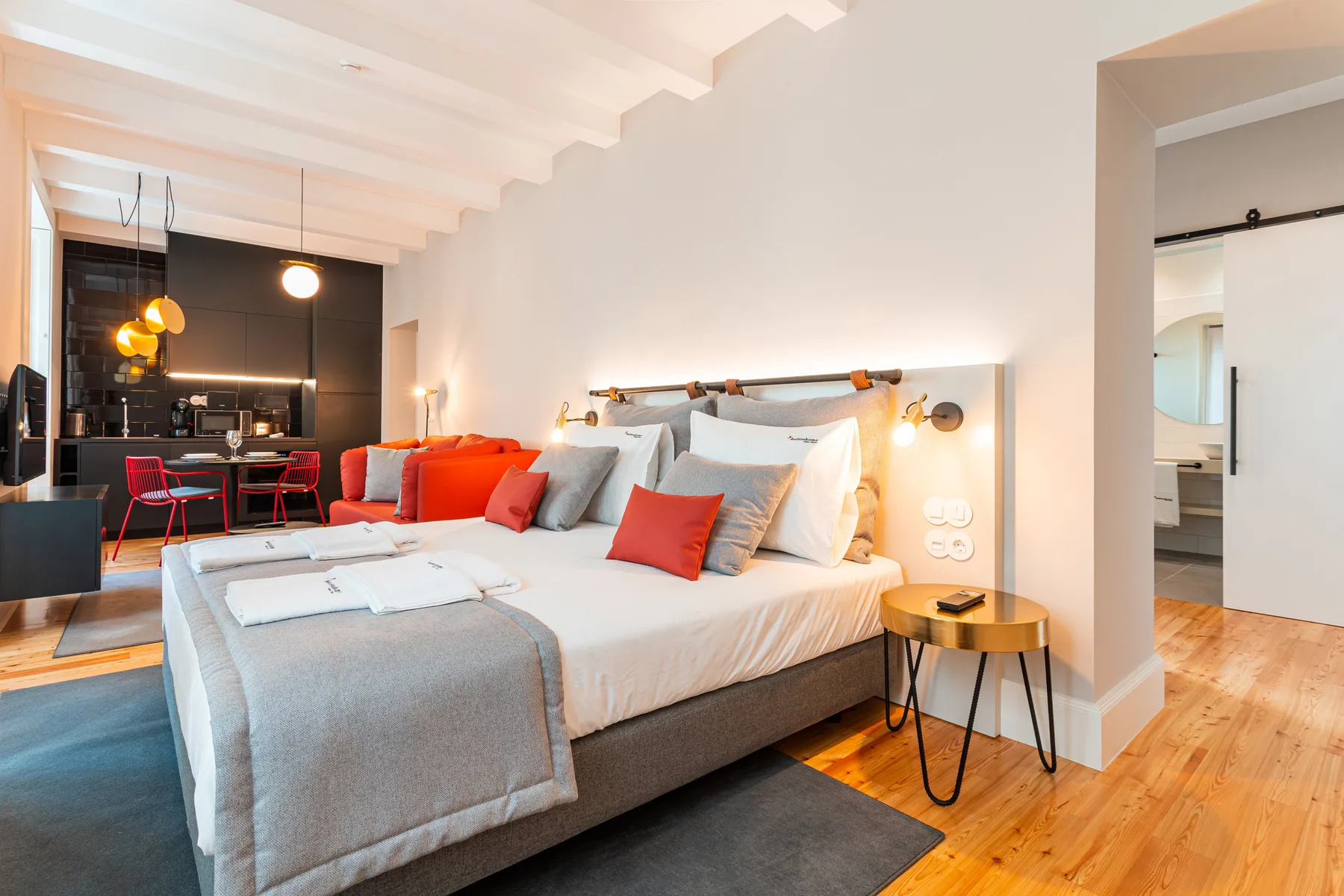 Un dormitorio con una cama grande y una zona de comedor al fondo.