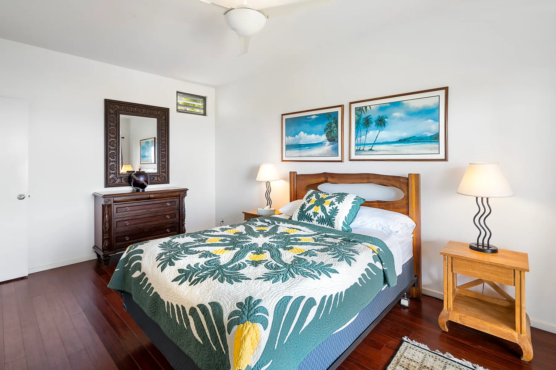 Un dormitorio con una cama de madera y ropa de cama con estampado tropical.