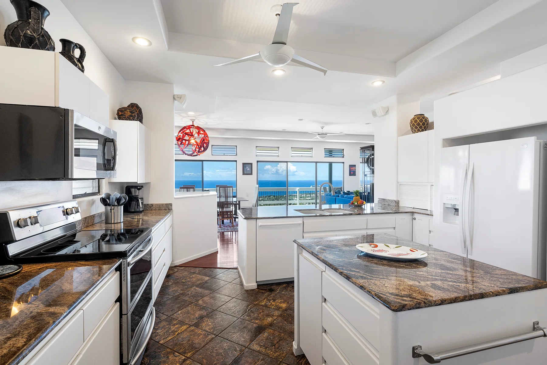 Una cocina luminosa con una isla central y grandes ventanas con vistas al agua.
