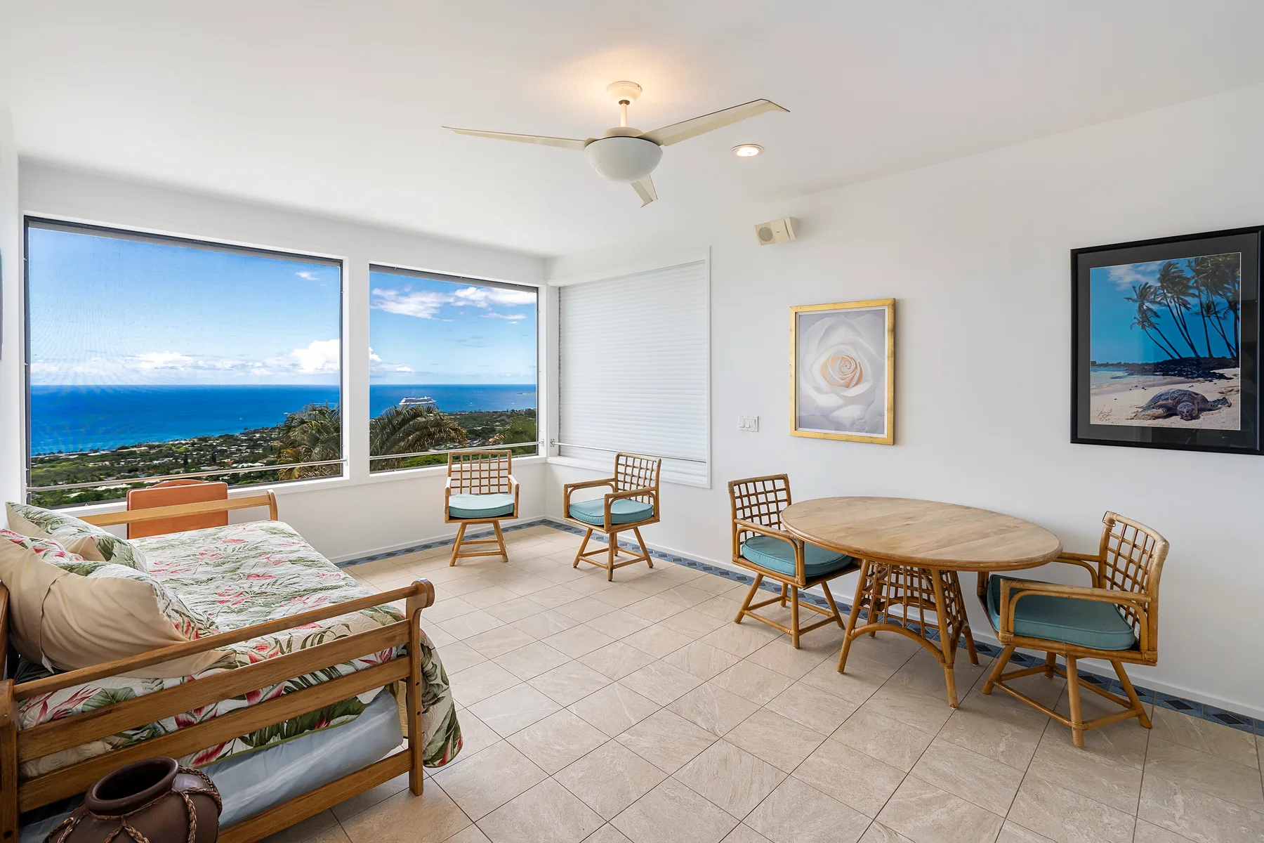 Una habitación luminosa con una mesa redonda y grandes ventanas con vistas al océano.