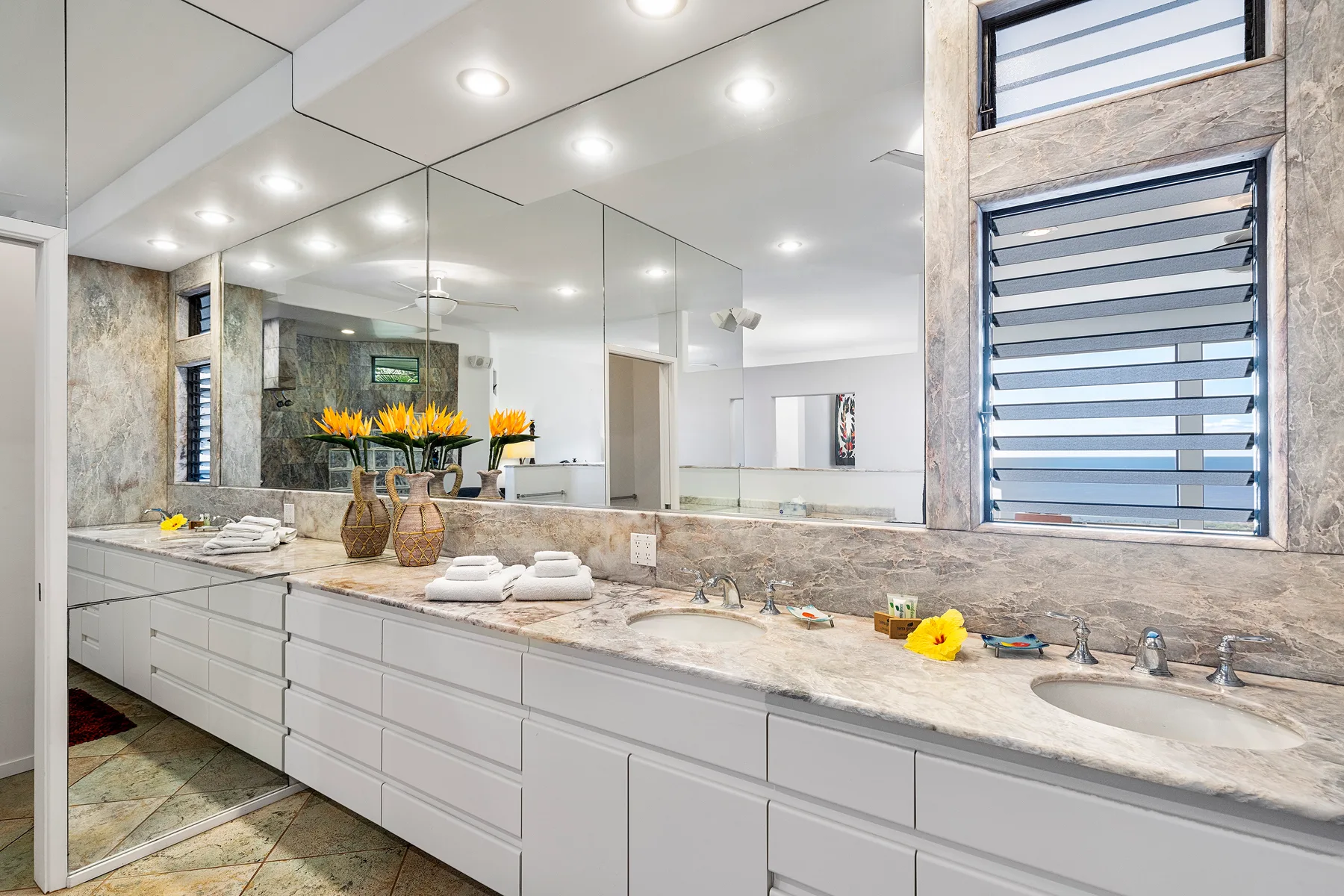 Un tocador de baño luminoso con un espejo amplio y lavabos sobre la encimera.