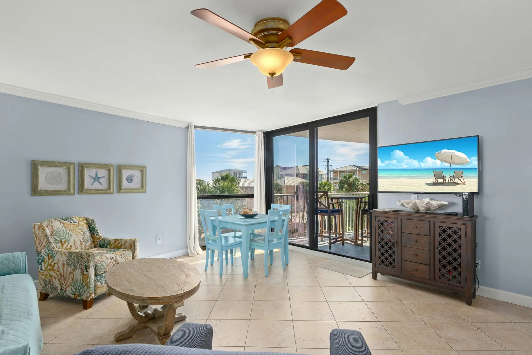 A bright living and dining area opens onto a balcony through sliding glass doors.