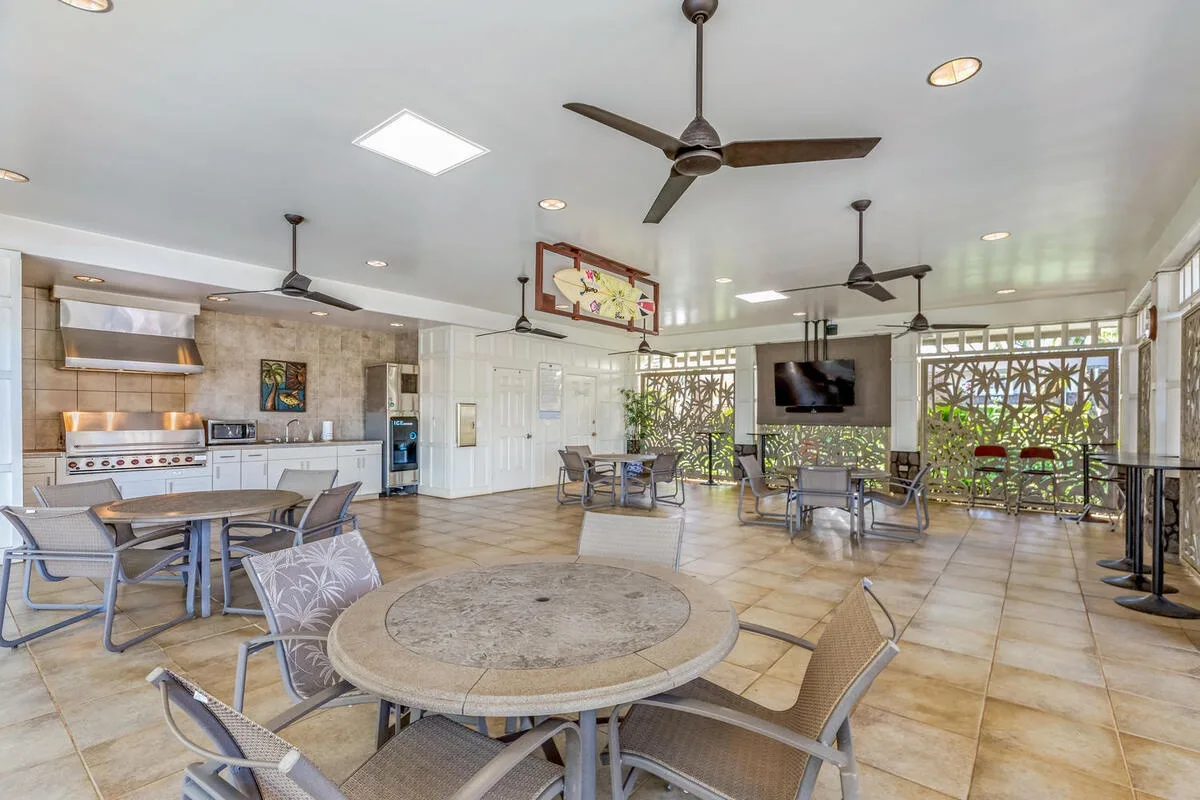 A spacious communal dining area with tables, seating, and a television.