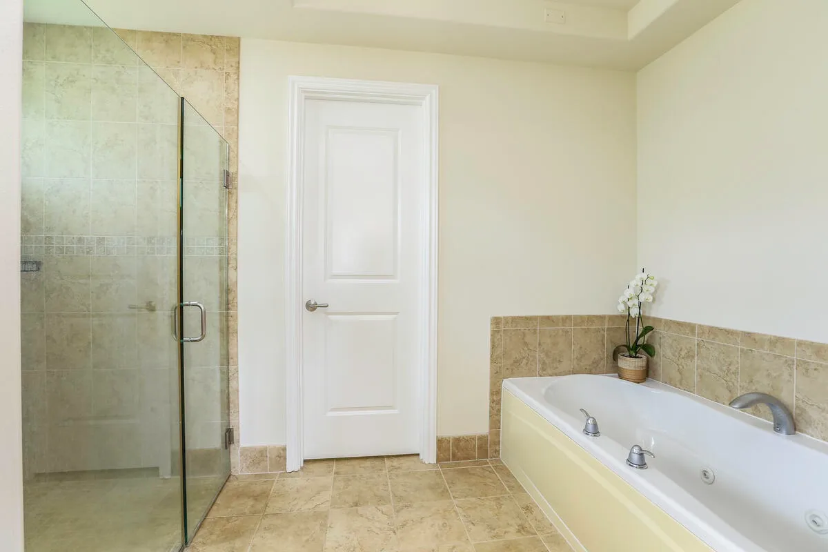 A bathroom with a glass shower and a built-in bathtub.
