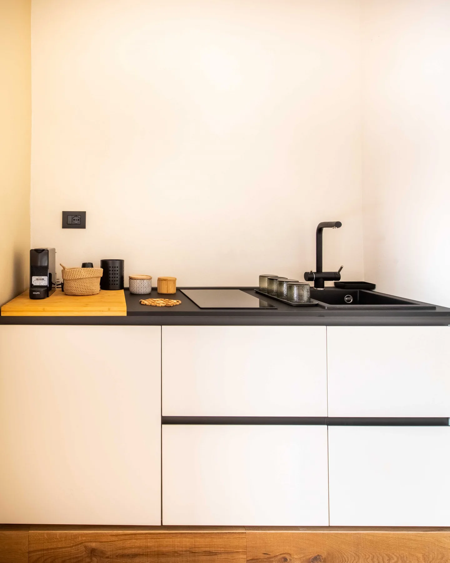 A modern kitchen counter with a sink, faucet, and small appliances.