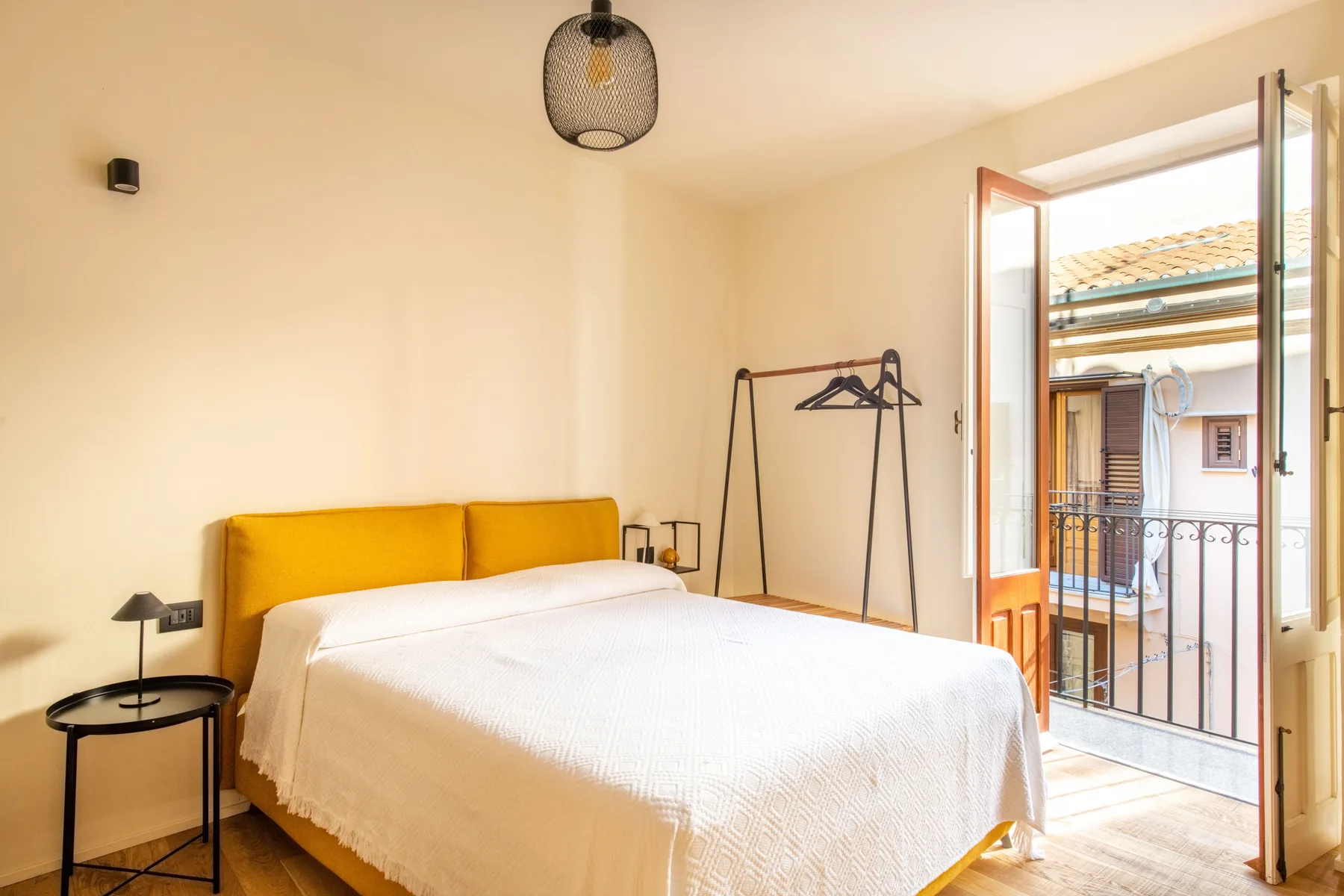 Un dormitorio con una cama y una puerta abierta al balcón.