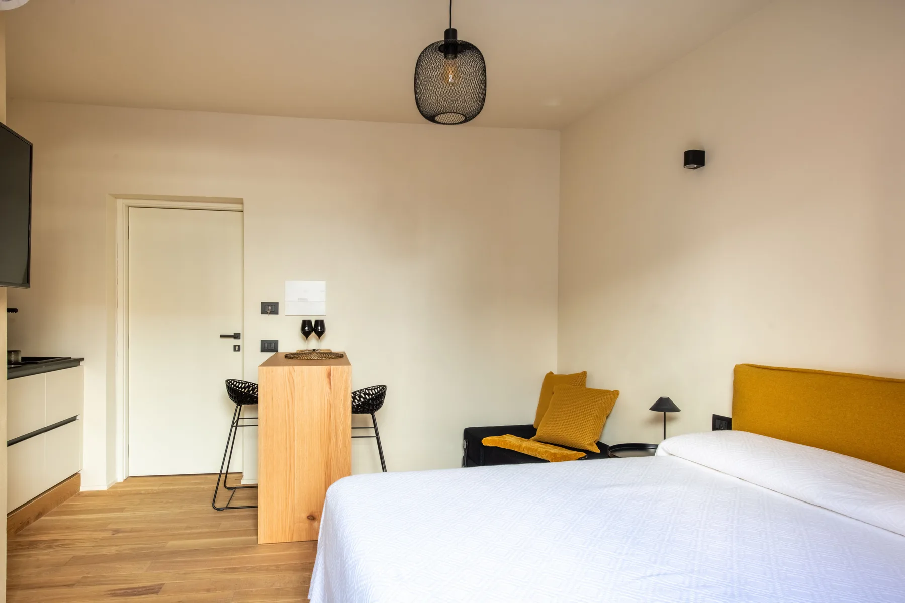 Un dormitorio con una cama, una pequeña mesa de comedor y asientos.