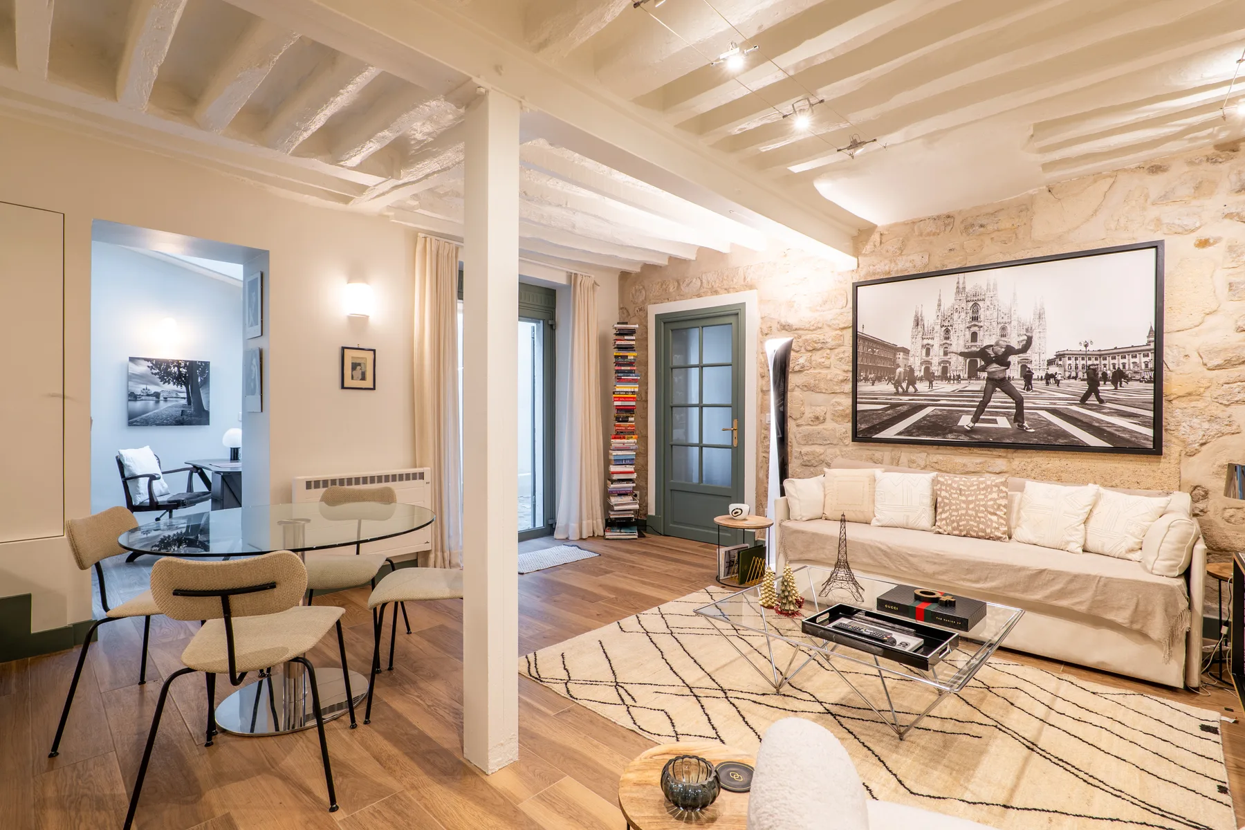 A living room with a sofa, rug, and large framed artwork on the wall.