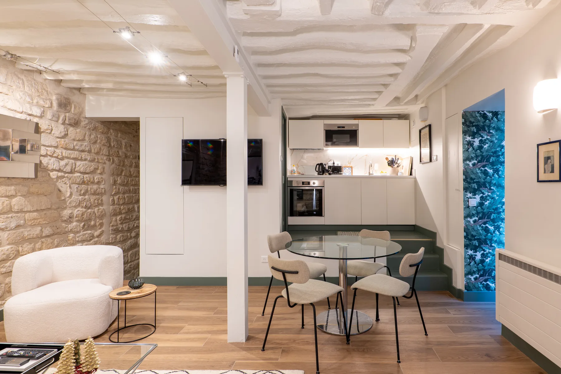 A bright open-plan room with a dining area and compact kitchen.