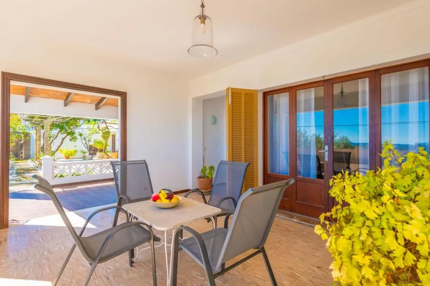 A bright patio dining area with outdoor seating beside large glass doors.