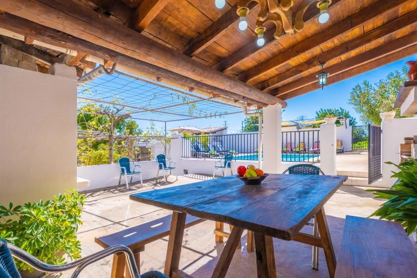 A shaded outdoor dining area opens onto a pool terrace.