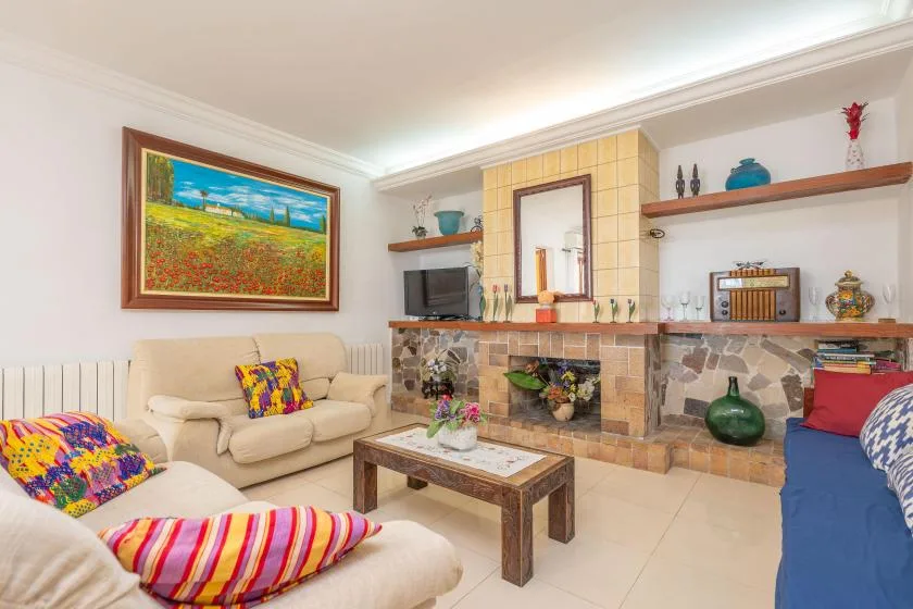 A living room with seating around a coffee table and a tiled fireplace.