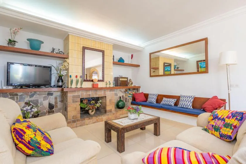 A living room with a tiled fireplace, seating, and a wooden coffee table.