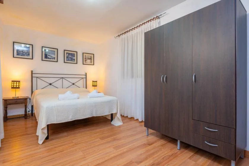 A bedroom with a bed, bedside tables, and a large wardrobe.