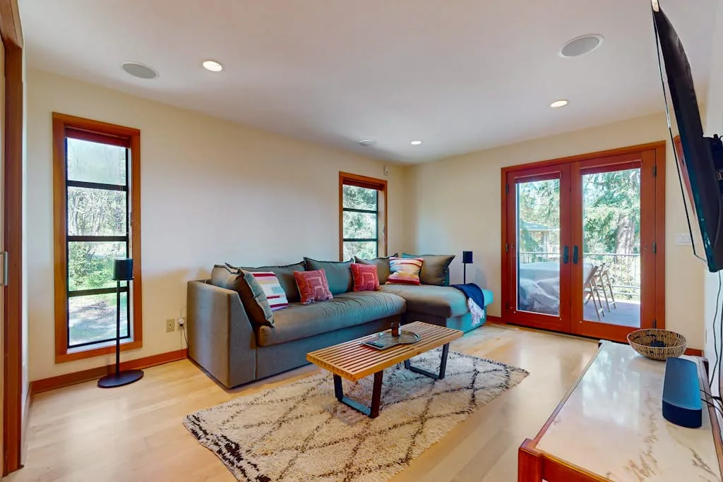 Living room with a sofa, area rug, and glass doors opening to a patio.