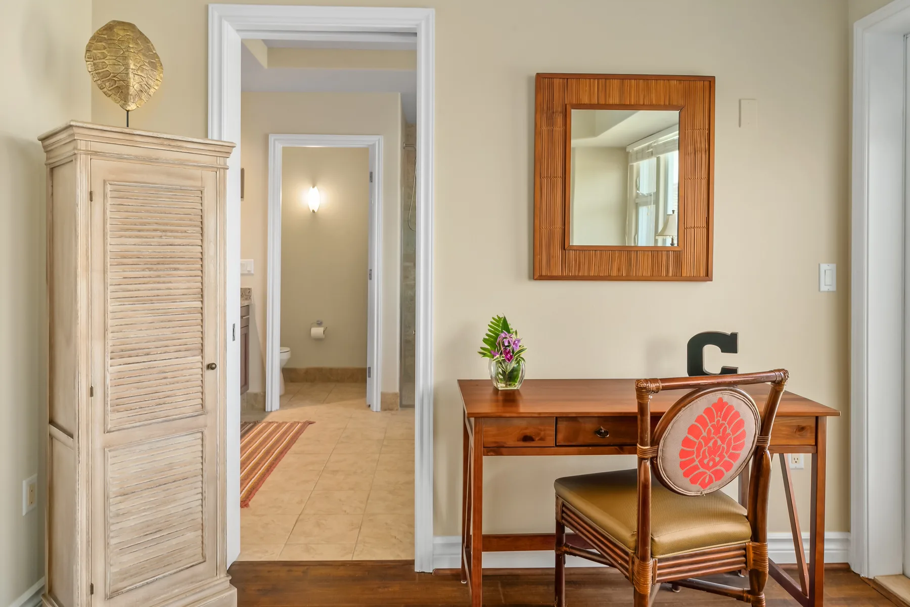 A desk and chair sit against a light-colored wall beside an open doorway.