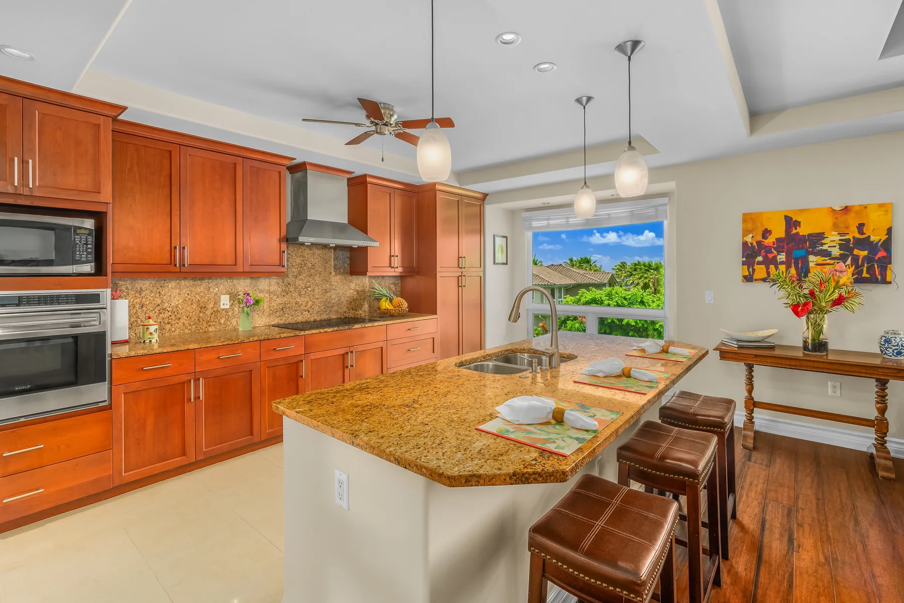 A kitchen with wooden cabinetry and a large island with a sink.