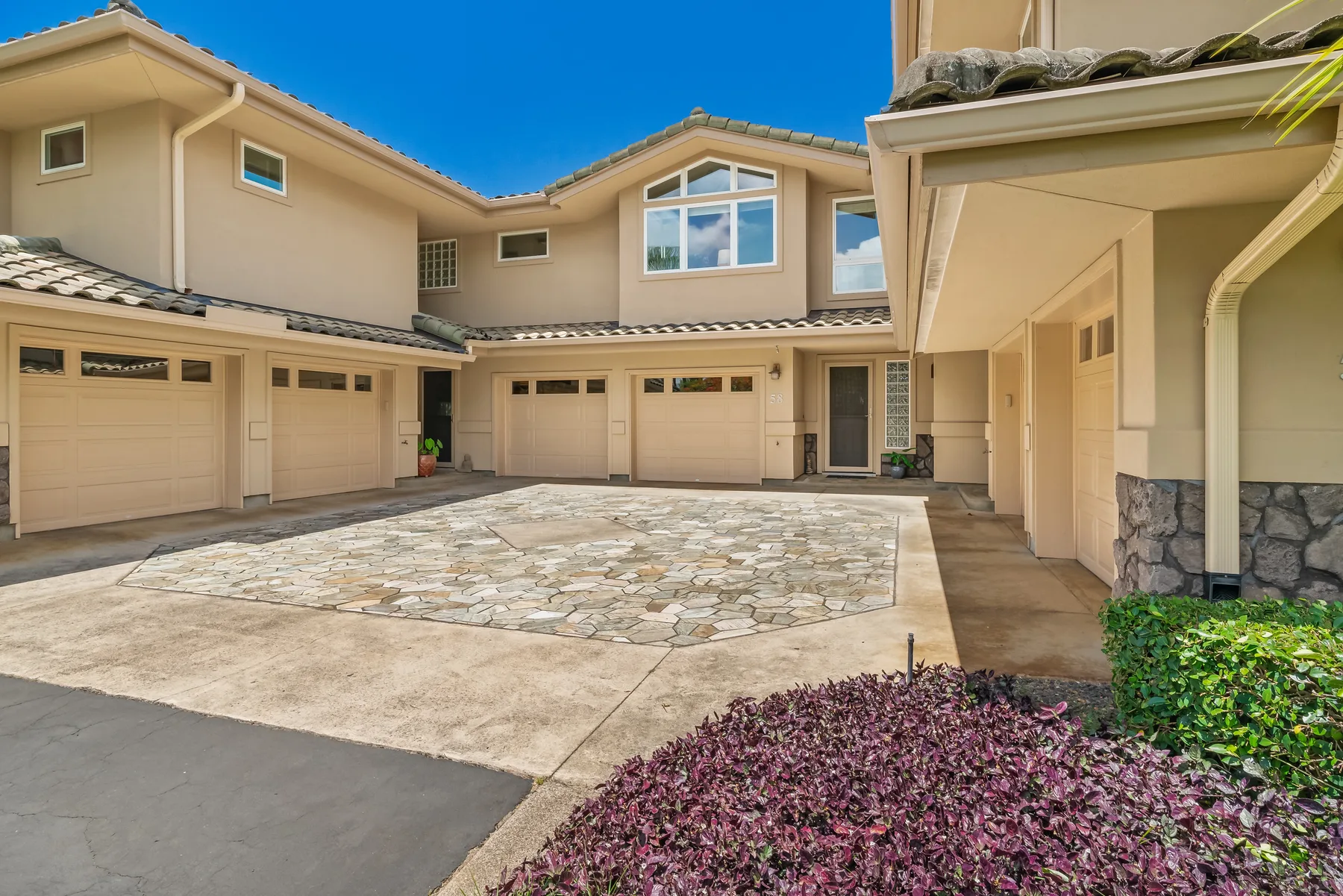 A paved courtyard in front of a multi-story building with garage doors.