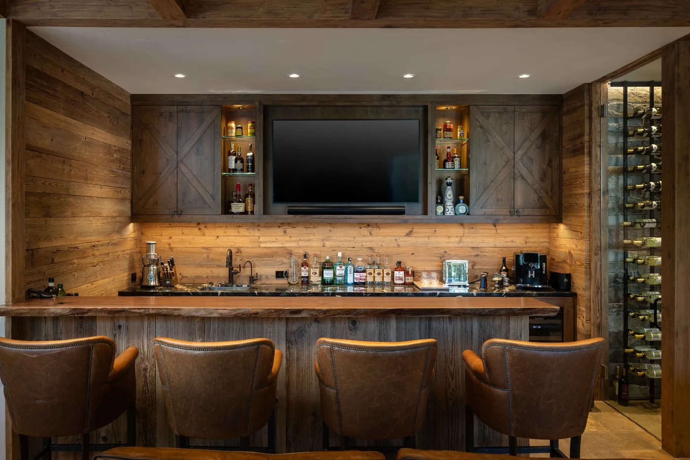 A wood-paneled bar area with a television, counter, and seating.