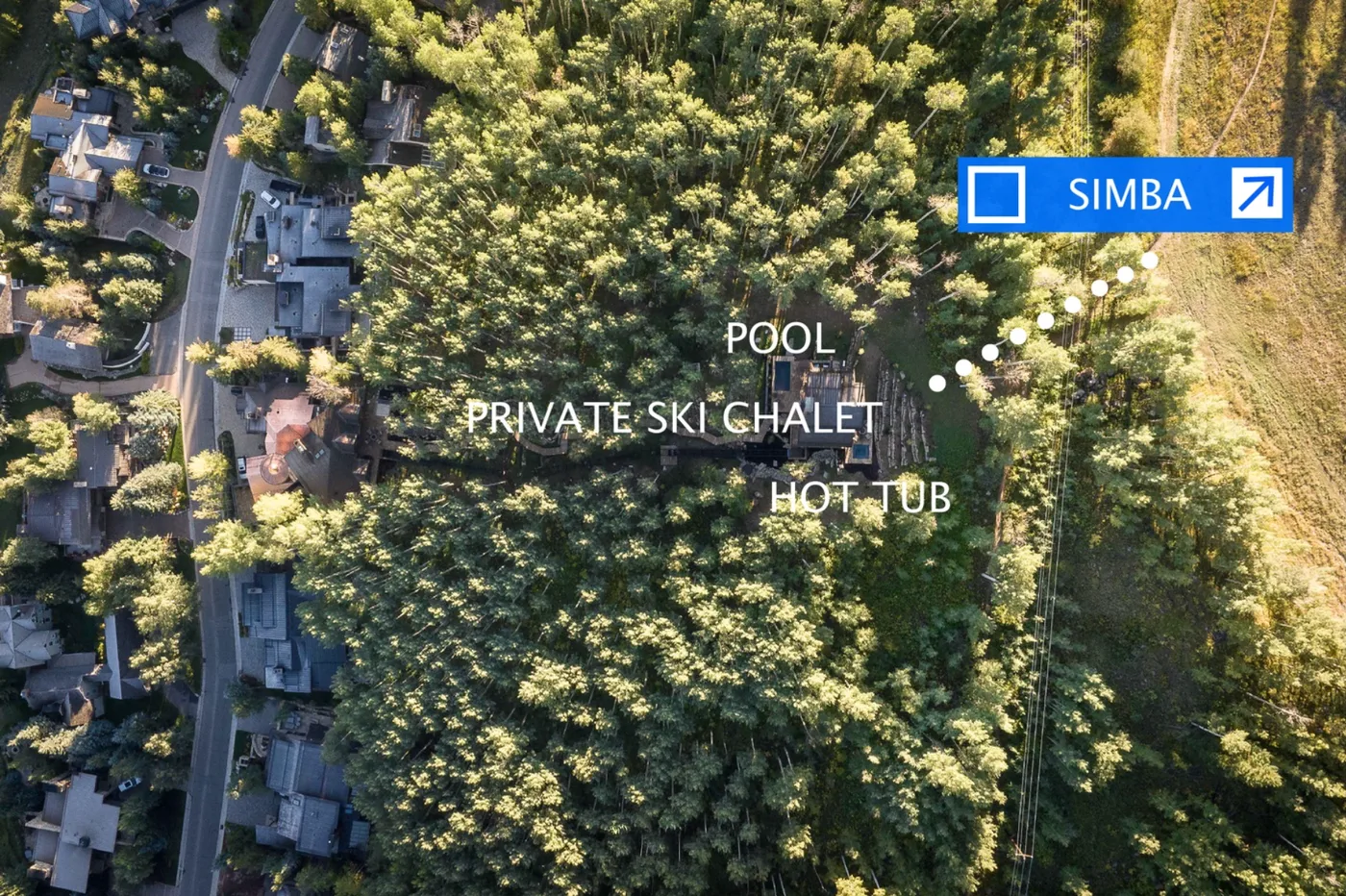 Aerial view of a wooded area with buildings and a marked route.