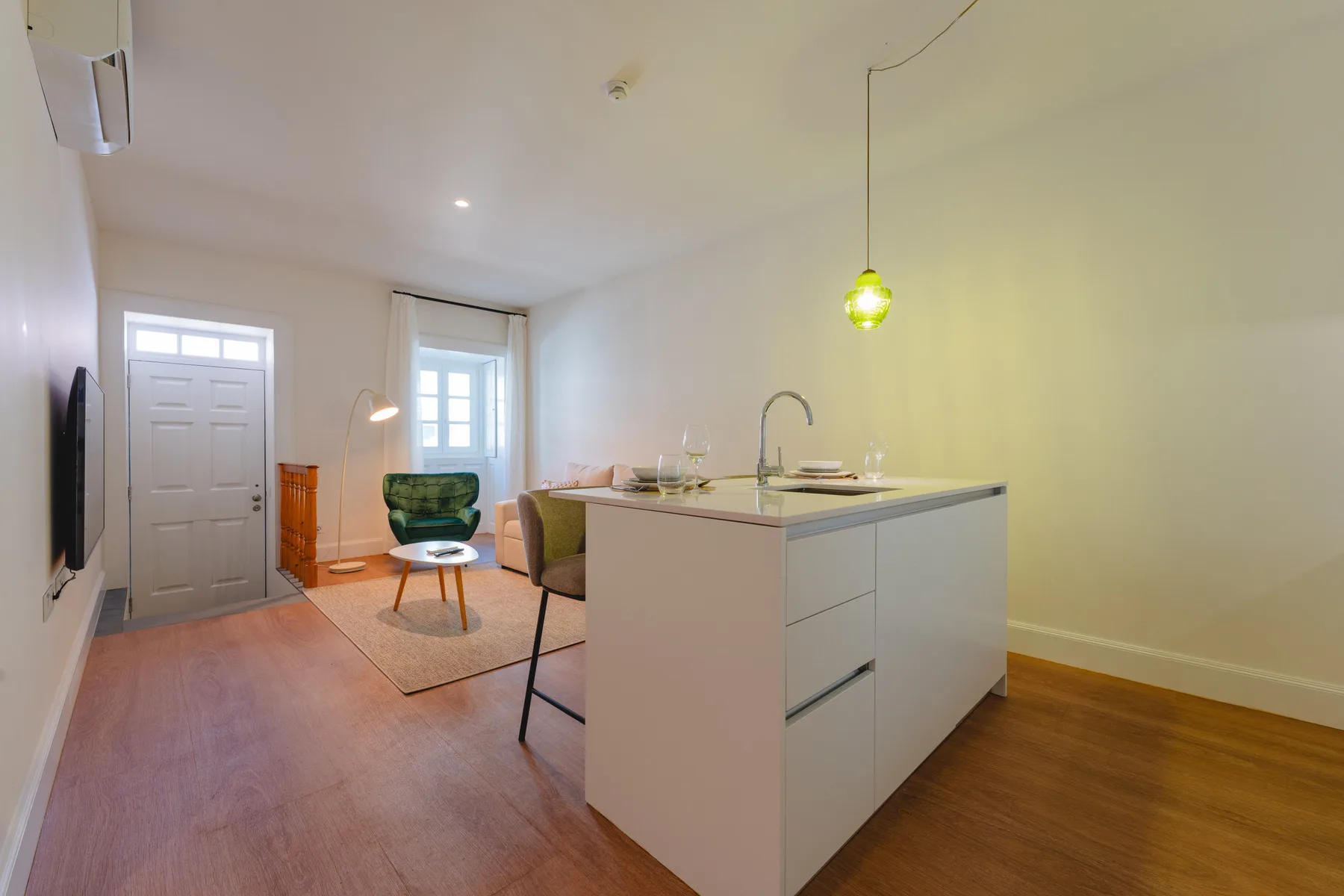 Una sala de estar diáfana con una isla de cocina y asientos.