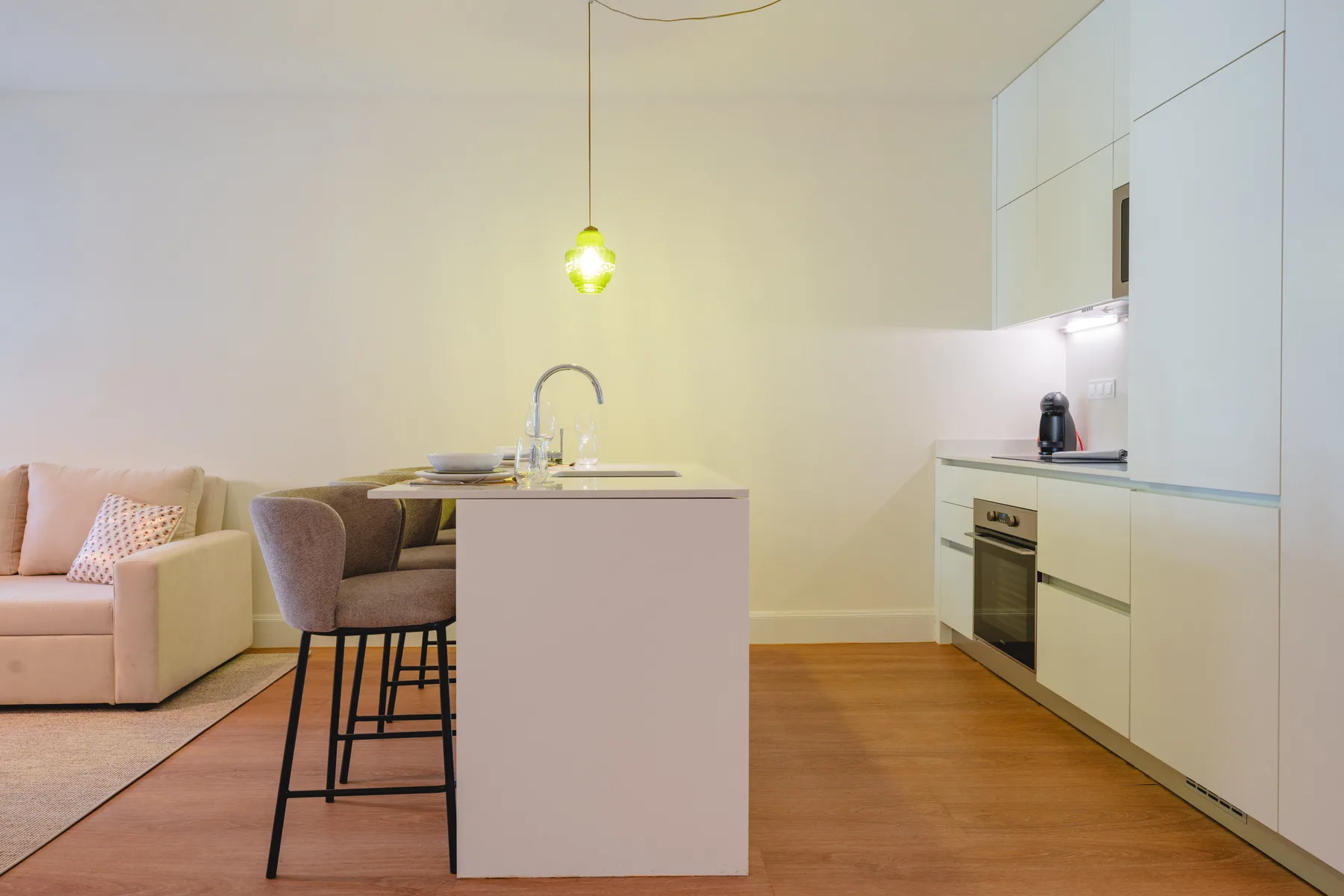 Una sala de estar y cocina de concepto abierto, con una isla central y asientos.