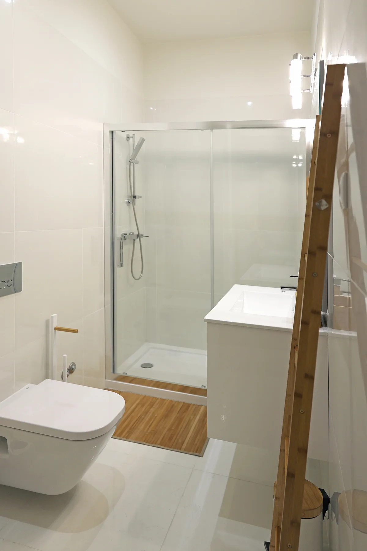 A bright bathroom with a glass shower and a white sink.