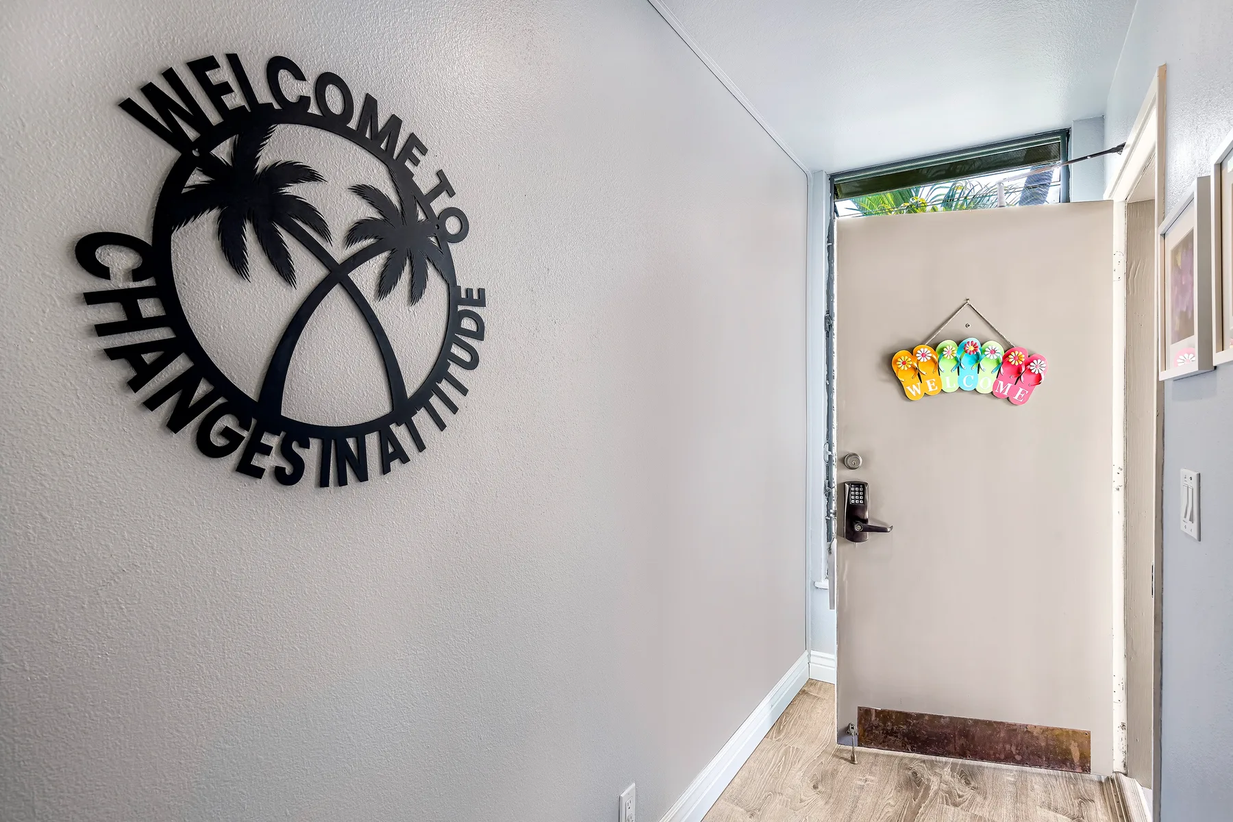 An entryway with an open door and a wall-mounted welcome sign.