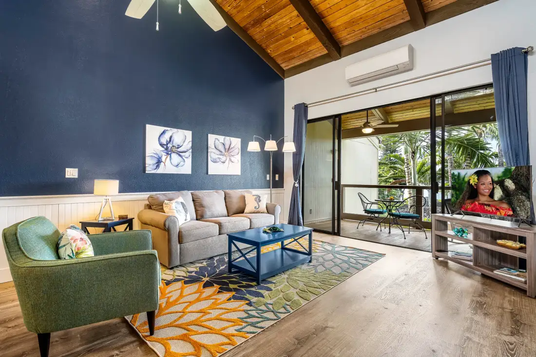 Sala de estar con asientos, una mesa de centro y puertas de vidrio que dan a un patio.