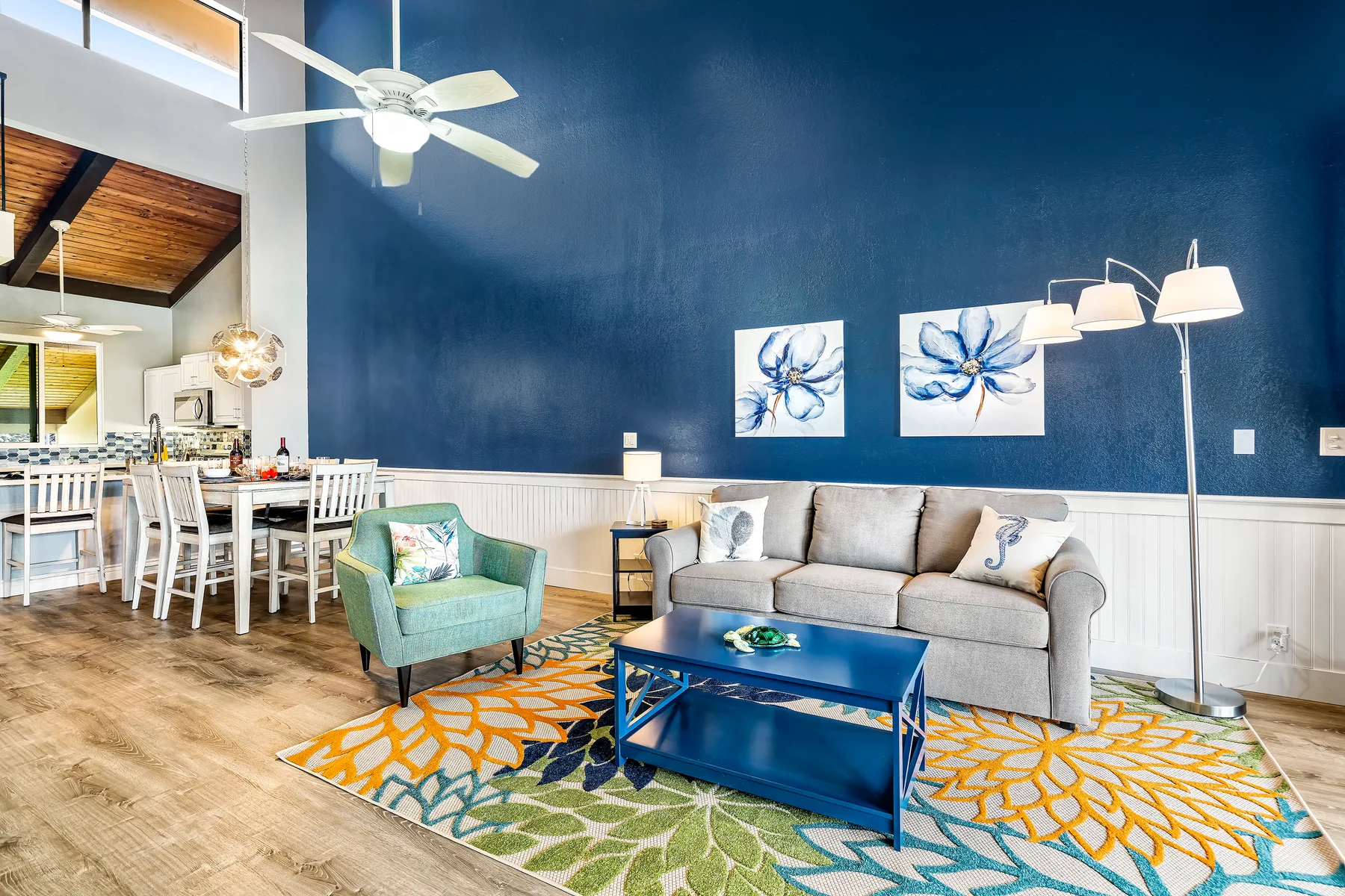 A living room with a gray sofa, blue coffee table, and colorful rug.