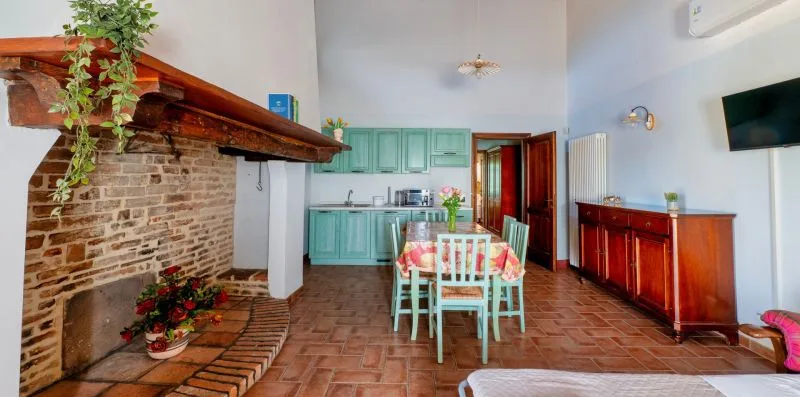 A dining area with a table and chairs beside a brick fireplace.
