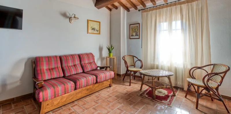 A sitting room with a plaid sofa, wicker seating, and a coffee table.