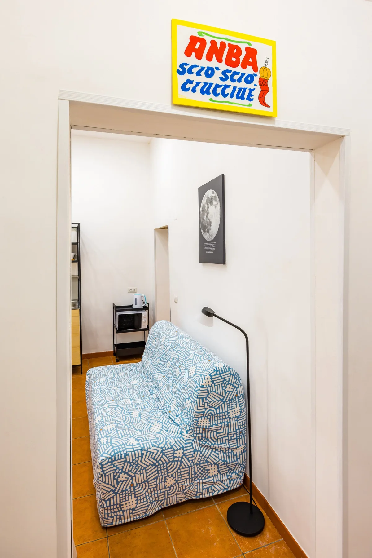 A small seating area with a patterned armchair and a floor lamp.