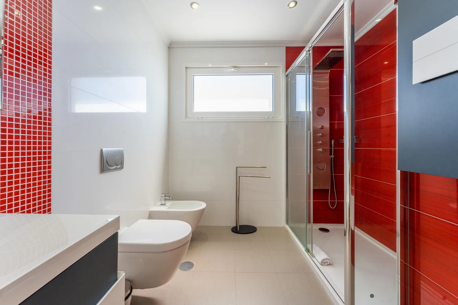Un baño con azulejos rojos, una ducha y un lavabo.