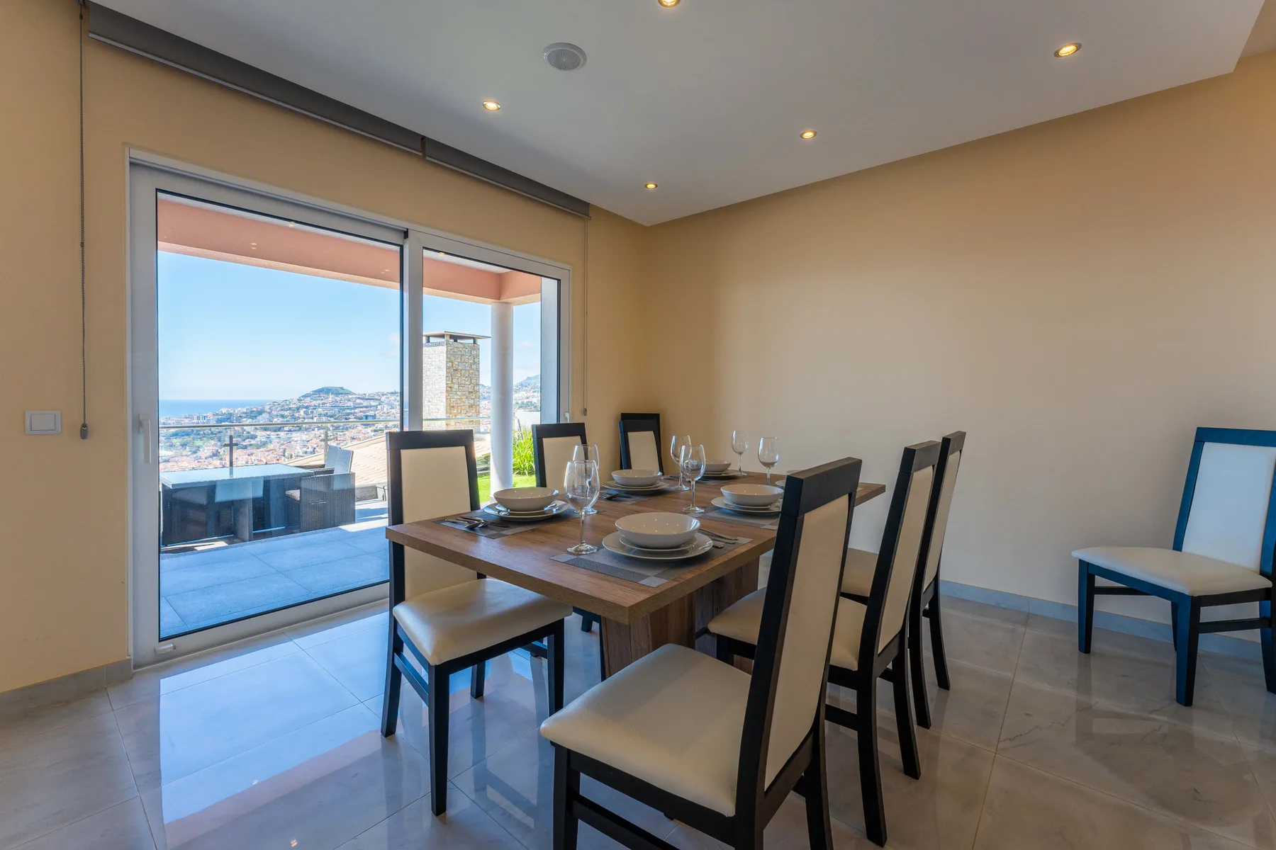 Comedor con la mesa puesta junto a grandes puertas corredizas de vidrio.
