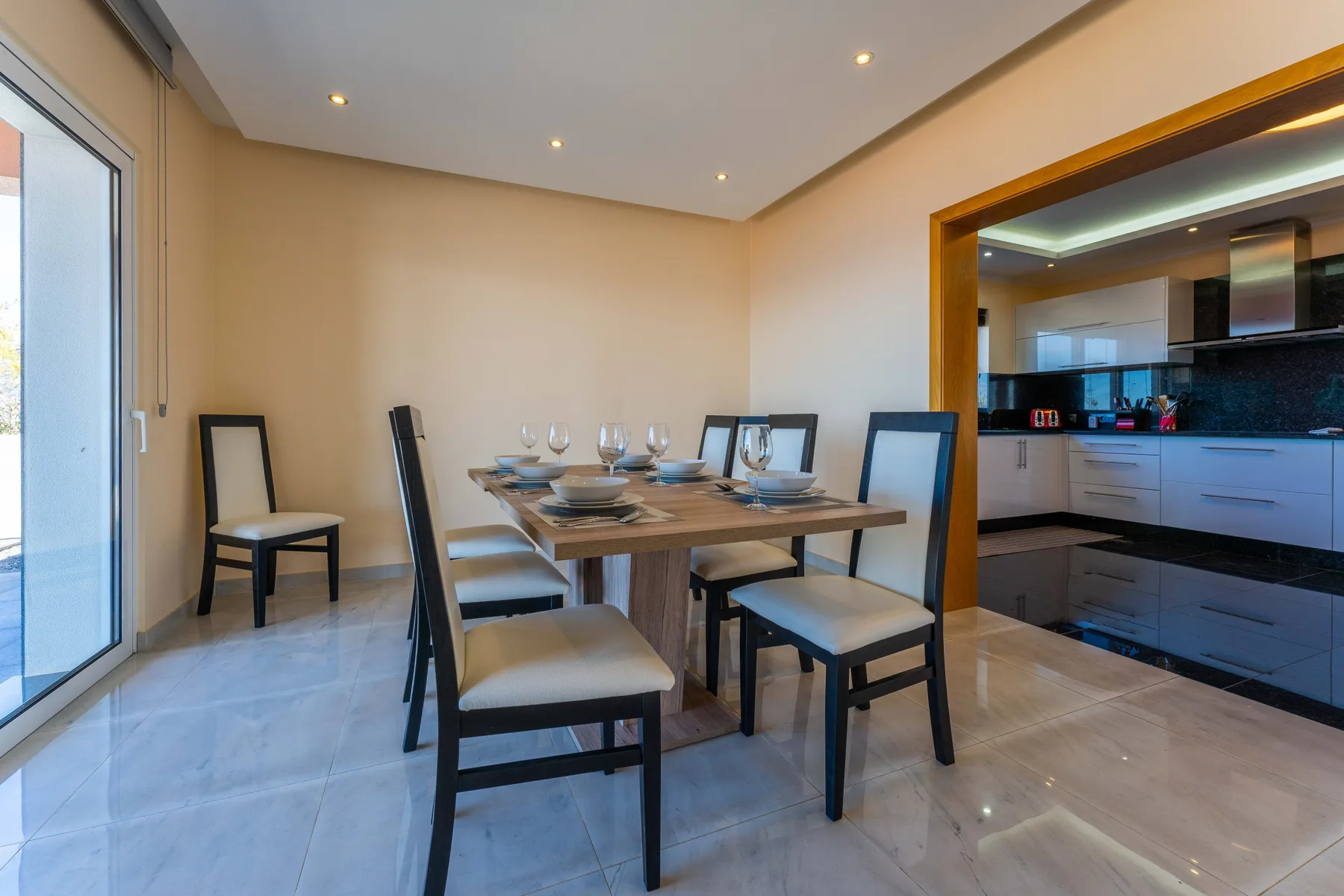 Comedor con la mesa puesta y una cocina contigua.