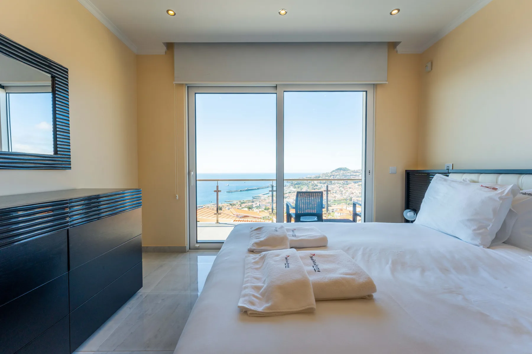 Un dormitorio con una cama y una puerta corredera de vidrio con vistas al mar.