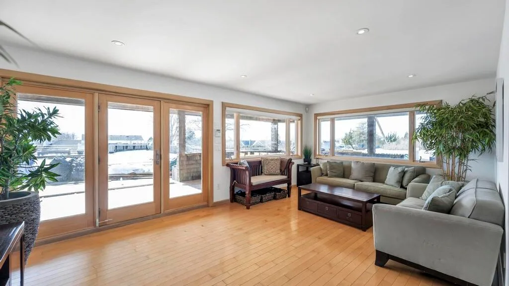 A bright living room with seating arranged beside large windows.