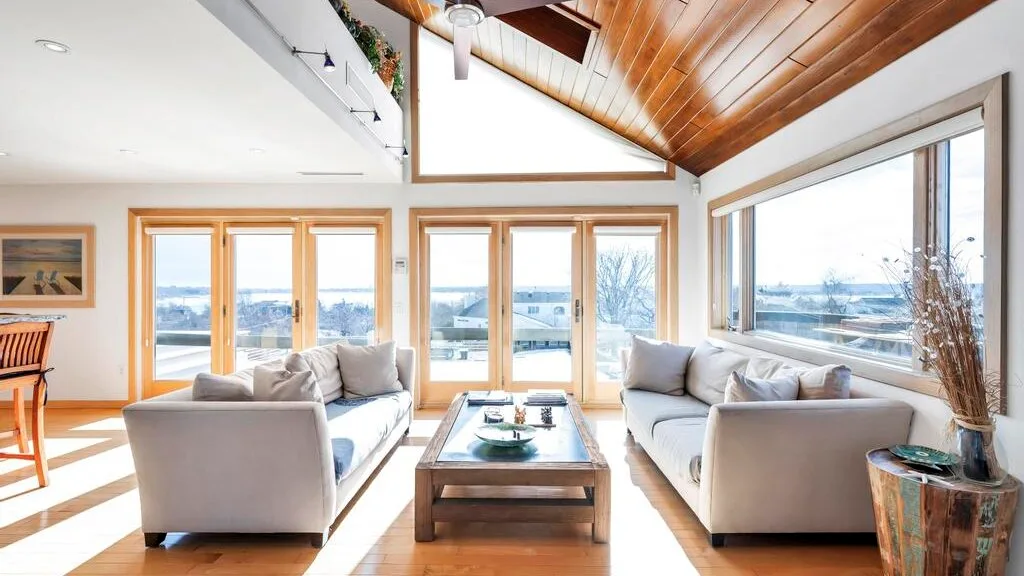 Una sala de estar luminosa con asientos alrededor de una mesa de centro baja de madera.